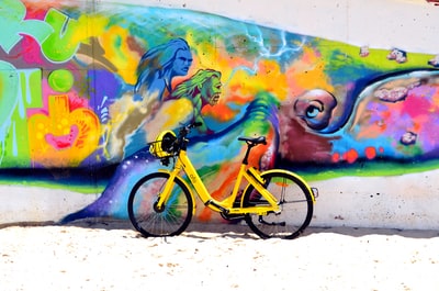 绿色自行车公园旁边的墙与人类绘画白天
